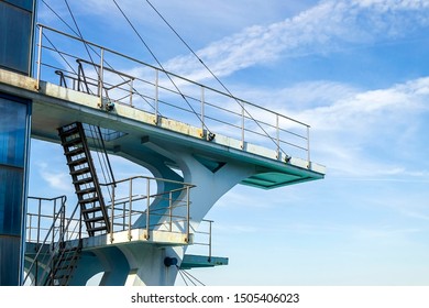 Multilevel Sport Diving Board In The Outdoor Pool On A Background Of Blue Summer Sky With White Clouds. Diving Into Water From A Diving Platform, Water Sports. Side View.