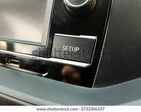 Multimedia system settings button on automotive dashboard