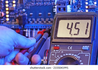 A multimeter in the hands of an engineer with the parameters of the voltage of the electric current in close-up.