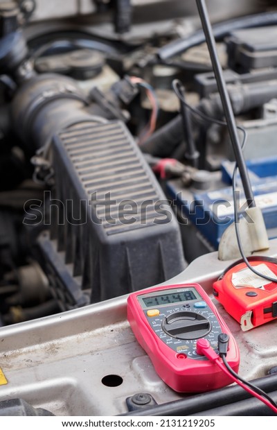 Multimeter\
measuring the voltage on a car\
battery.