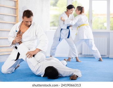 Multinational athletes in sparring practice technique practicing basic attacking movements and maneuvers. Class oriental martial arts training. Sport to max - Powered by Shutterstock