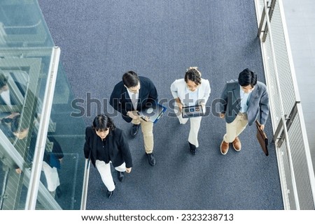 Multinational business group walking in lobby. Global business. High angle view.