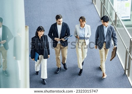 Multinational business group walking in lobby. Global business. High angle view.
