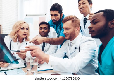 Multinational Doctors Duscussing. Patient's Pelvis X-ray. Group Specialist Connection Interacting. Hospital Diagnostic Meeting. Medical Results. Clinician Team Group. Physician Assistants.