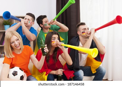 Multinational Friends Blowing By Vuvuzela During The Football Match