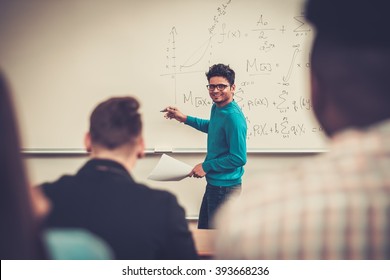 Multinational group of cheerful students taking an active part in a lesson while sitting in a lecture hall.