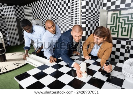 Multinational group of colleagues trying to find solution of conundrum in quest room