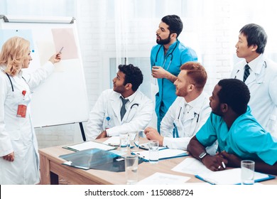 Multinational Medician Consultation. Head Doctor Discussing. Information On Paper Desk. Medical Teamwork Connection. Clinician Team Group. Hospital Diagnostic Meeting. Physician Assistants. - Powered by Shutterstock