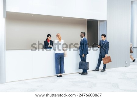 Multinational people checking in at a hotel front desk