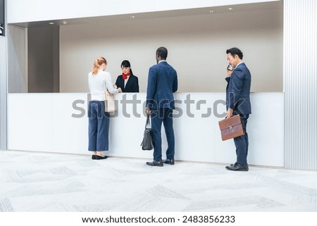 Multinational people checking in at a hotel front desk