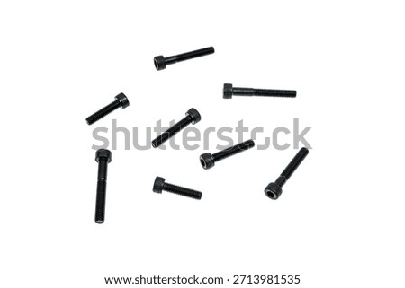 Multiple black allen head cap screws scattered randomly on a clean white background.