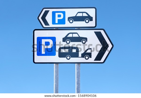 Multiple car parking and caravan motorhome signs\
against blue sky