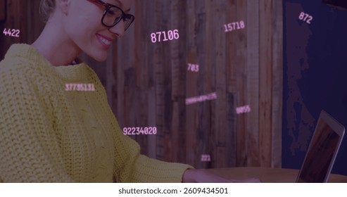 Multiple changing numbers floating against caucasian woman smiling while using laptop. global networking and connection concept