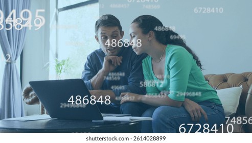 Multiple changing numbers floating over caucasian couple calculating finance together at home. budget and finance concept