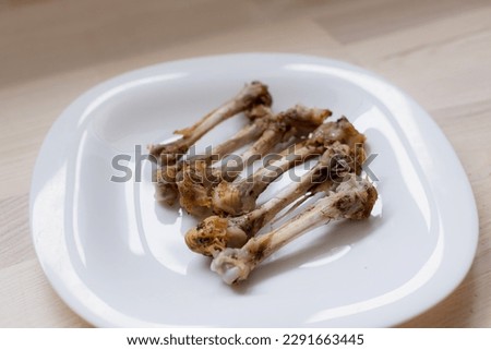 Multiple chicken bones on a white plate