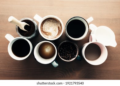 Multiple coffee cups, milk, beans and ground coffee in jar on wooden background. High quality photo