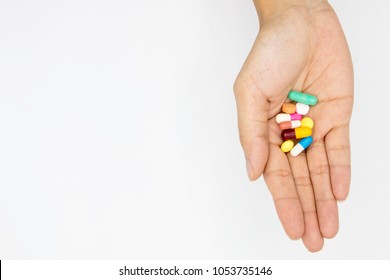 multiple colors pills in  hand  on white background, Taking Your Medication.