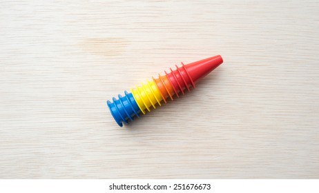 Multiple colour mini plastic safety cones on wooden surface. Slightly de-focused and close-up. Shot with natural light. Concept of work in progress. Copy space.