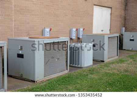 Multiple Commerical Air Conditioner Compressors outside brick building