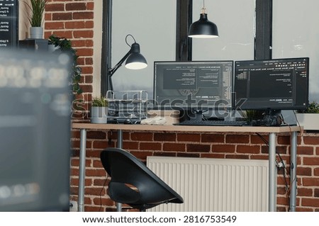 Multiple computer monitors display parsing code and programming language compiling in an empty software development agency office.