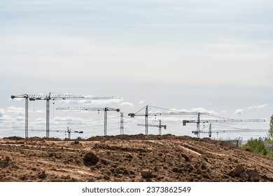 Multiple construction cranes that stand out on the horizon in new areas of expansion, Madrid, Spain.