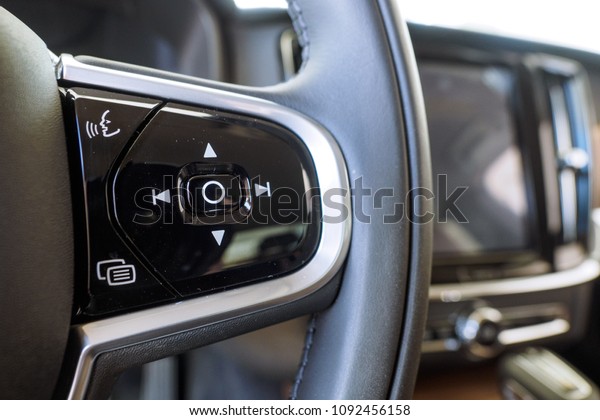 Multiple\
controls integrated in the wheel car. Modern car interior, gray\
steering wheel with media phone control buttonsto accept or reject\
calls, screen multimedia system background.\

