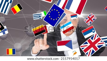 Multiple country flags against caucasian businessman touching invisible screen. international relations and business technology concept