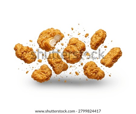 Multiple crispy fried chicken nuggets flying and scattered in the air with small crumbs, isolated on a clean white background