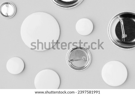 Multiple different sized badges  on a grey background.