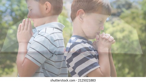 Multiple exposure of caucasian elementary boys praying against trees and bible on table. spirituality, religion, worshipper, meditation, hands clasped, christianity and national day of prayer. - Shutterstock ID 2125021883