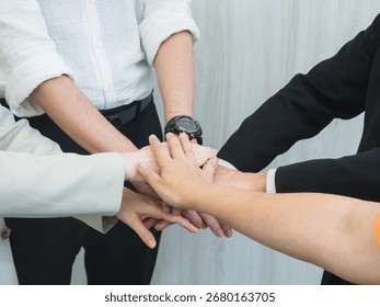Multiple hands stacked together symbolizing teamwork, unity, and collaboration in a professional or corporate environment. A powerful representation of mutual support and shared goals.