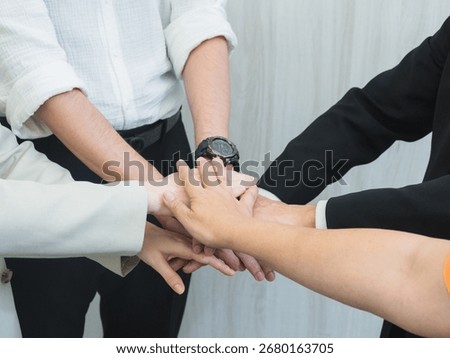 Multiple hands stacked together symbolizing teamwork, unity, and collaboration in a professional or corporate environment. A powerful representation of mutual support and shared goals.