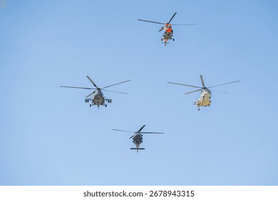 Multiple helicopters performing coordinated maneuvers in a clear blue sky during an air show