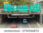Multiple Interstate Direction Signs over Highway Tunnel in Washington DC. U.S.A.

Vehicles pass beneath large freeway signs directing drivers toward Richmond, Southwest Waterfront, and local DC exits. A transportation-focused view of urban driving routes.