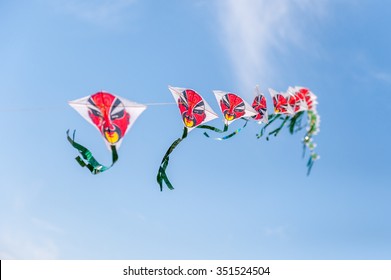 Multiple Kites Connected In Sky With Red Faces