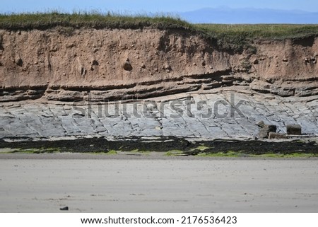 Multiple layers of geological strata on cliff face on north of Annstead Beach between Seahouses and Beadnell, Northumberland, England