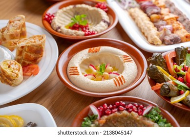Multiple Lebanese appetizers and salads together on the table. focused on  hummus