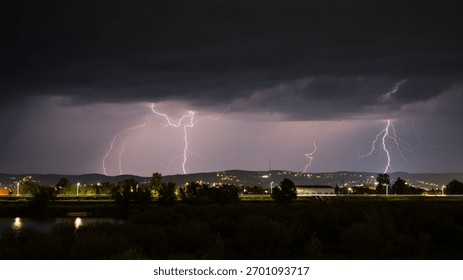 Multiple lightning during thunderstorm at night, over hills near croatian city of Slavonski Brod