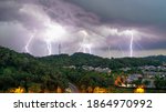multiple Lightning strikes during thunder storm over a hill view