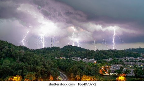 multiple Lightning strikes during thunder storm over a hill view