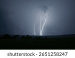 Multiple lightnings striking open fields 