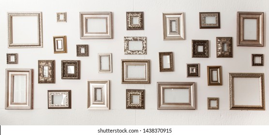 Multiple Many Blank Small Picture Frames On White Wall