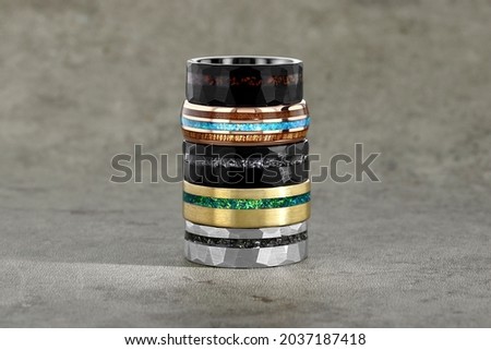Multiple Mens Tungsten Rings Stacked on a Stone Background for Engagement