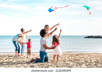 Multiple Mixed Families Composed By Parents And Children Playing With Kite At Beach Vacation - Summer Joy Life Style Concept With Candid People Having Fun Together At Seaside - Bright Vivid Filter