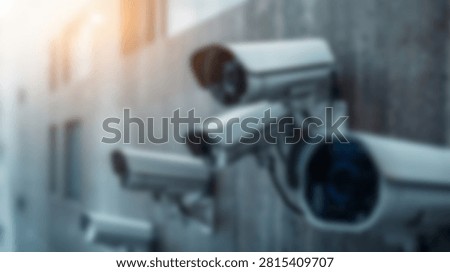 Multiple modern surveillance security cameras are mounted on a building exterior, suggesting a focus on monitoring and protection in an urban environment.