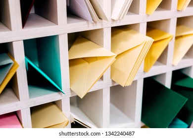 Multiple piles of various postal envelopes arranged on a shelf by color and type categories. Sorted paper mail covers in library/office. - Shutterstock ID 1342240487