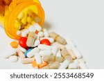 Multiple pills spilling out of an orange prescription bottle