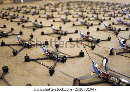 Multiple Racing Drones Lined Up on Concrete Floor