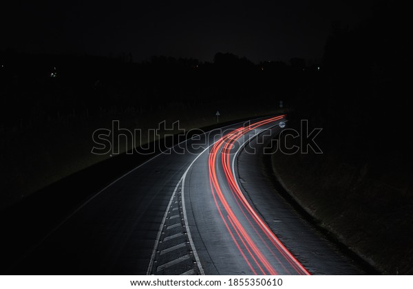 multiple red car light\
trails at night