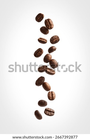Multiple roasted coffee beans are falling against a clean white background. The beans are in various positions, showcasing their rich brown color and texture.